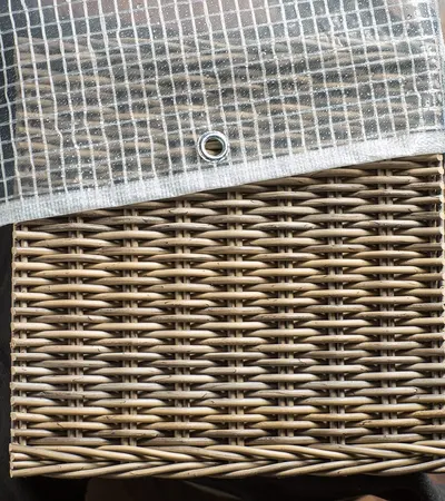 Transparente Gitterfolie mit Öse auf einem Rattanmöbel